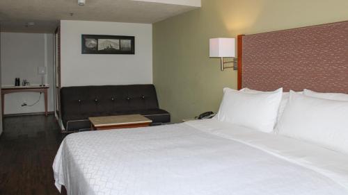 a hotel room with a large bed and a couch at Holiday Inn Orizaba by IHG in Orizaba