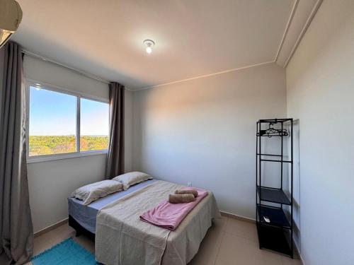 a bedroom with a bed and a window at Apartamento de 02 quartos com vista para o lago in Palmas