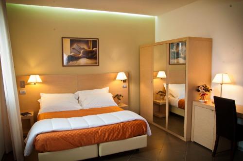 Pokój hotelowy z łóżkiem i lustrem w obiekcie Hotel Main Street w mieście Cerasolo