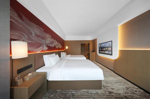 a large white bed in a hotel room at Guangzhou Huayu Wanfu Hotel-Free Shuttle Bus to Canton Fair Complex During Canton Fair Period in Guangzhou