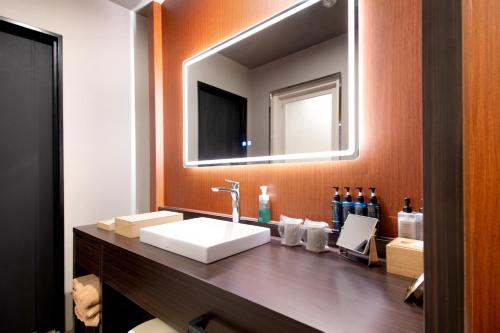 a bathroom with a sink and a mirror at Hotel Chapel Sweet (Adult Only) in Kobe