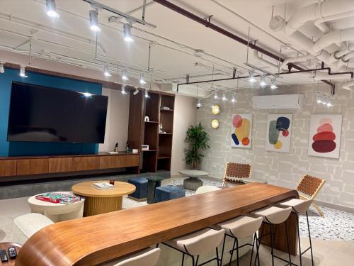 a large room with a table and a flat screen tv at Apartamento Lirios Tegucigalpa in Tegucigalpa