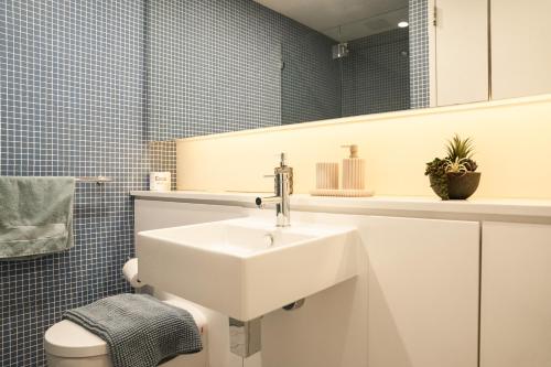 a bathroom with a white sink and a mirror at Harbour Hideaway in the CBD in Sydney