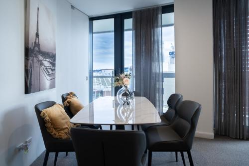 a dining room with a glass table and chairs at Harbour Hideaway in the CBD in Sydney