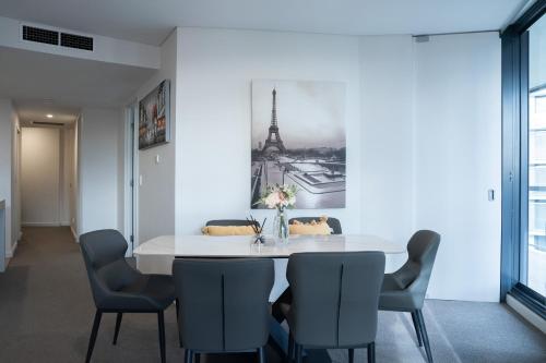 a dining room with a white table and chairs at Harbour Hideaway in the CBD in Sydney