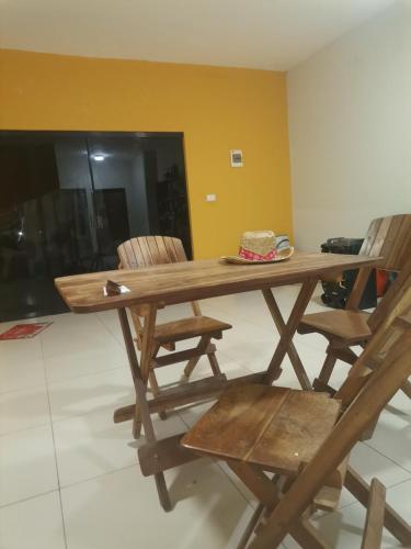 a wooden table and chairs with a hat on it at Habitación con baño privado mas servicio de taxi aeropuerto in Santa Cruz de la Sierra