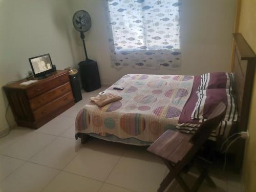 a bedroom with a bed and a dresser and a window at Habitación con baño privado mas servicio de taxi aeropuerto in Santa Cruz de la Sierra