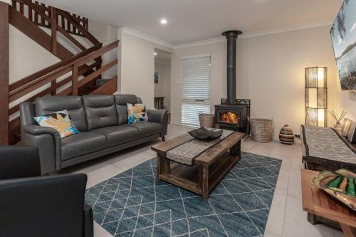 a living room with a couch and a fireplace at Amaroo Sunset Lodge in Smiths Lake