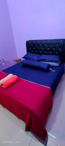 a bedroom with two beds with red and blue sheets at Putera homestay in Juasseh