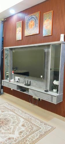 a large flat screen tv on a wooden wall at Putera homestay in Juasseh
