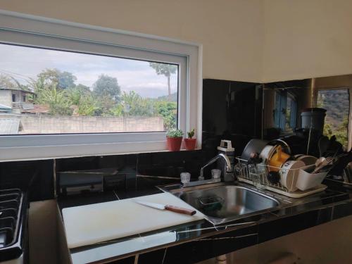 eine Küchentheke mit Spüle und Fenster in der Unterkunft Hiking San Juan in Cataltzul