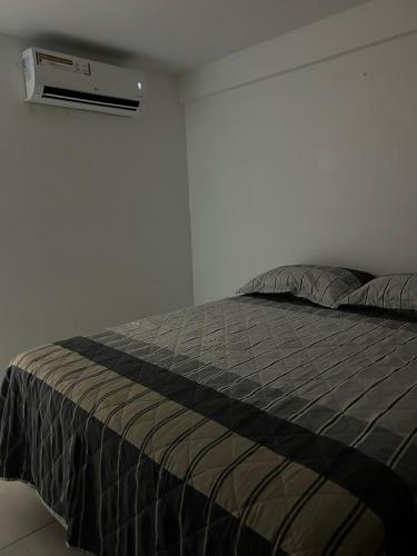 a bedroom with a bed with a air conditioner on the wall at Studio One 1107 in Juazeiro do Norte