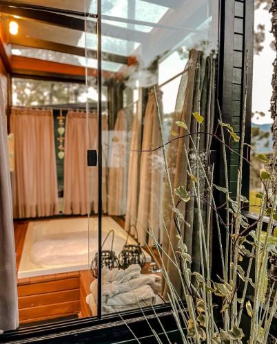 a glass room with a bed in the background at La Serena Cabanas in Urubici