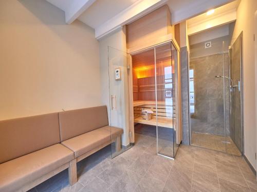 La salle de bains est pourvue d'un banc et d'une douche. dans l'établissement Ferienhäuser im Torfhaus Harzresort, Torfhaus, à Torfhaus