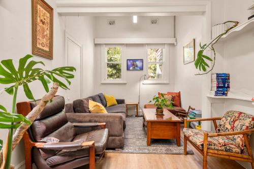 a living room with a couch and chairs and a table at Art House in Melbourne