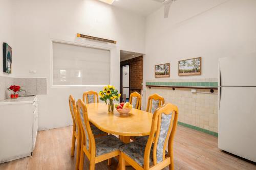 a kitchen with a wooden table with chairs and a refrigerator at Art House in Melbourne