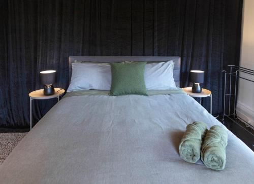 a large bed with two nightstands and two lamps at Art House in Melbourne