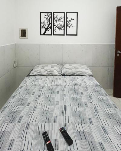 a bed with two remote controls on top of it at AP número 1 in Governador Celso Ramos