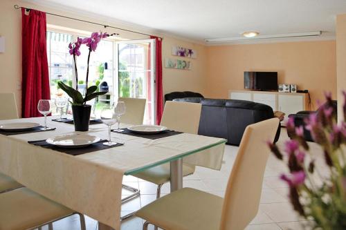 a dining room with a table with glasses and purple flowers at Cottages at the Kummerower See in Verchen in Verchen