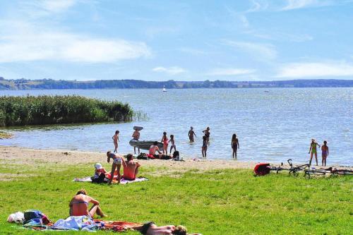 a group of people on a beach near the water at Cottages at the Kummerower See in Verchen in Verchen