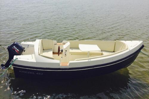 a small boat sitting in the water at Cottages at the Kummerower See in Verchen in Verchen