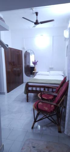 a bedroom with a bed and a mirror and a chair at Alappuzha Family Vacation Villa - LAYANILA in Alleppey