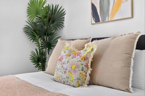a pillow sitting on a bed next to a plant at Relaxing Rockingham Hub for Business Travellers in Rockingham