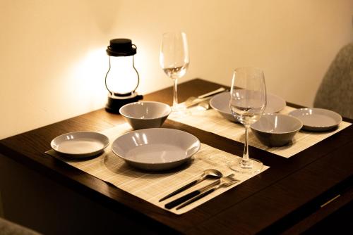 a wooden table with plates and glasses on a table at Morinest 北軽井沢 in Tsumagoi