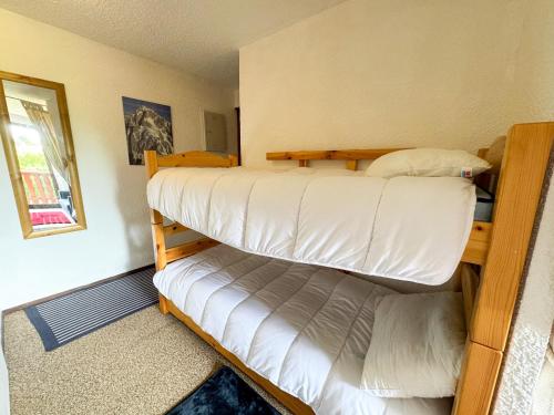 two bunk beds in a room with a window at Appartement au pied des pistes à Bernex avec balcon et parking - FR-1-498-117 in Bernex