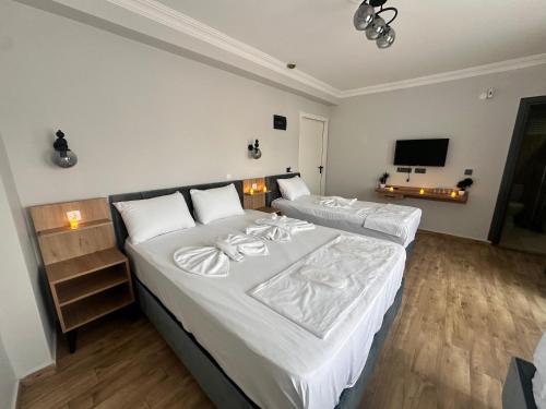 a bedroom with two beds and a flat screen tv at Avka Palace in Edirne