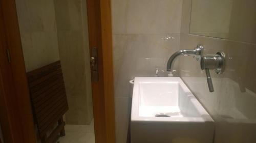 a bathroom with a white sink and a mirror at Marginal Luminous Beach Apartment in Vila do Conde