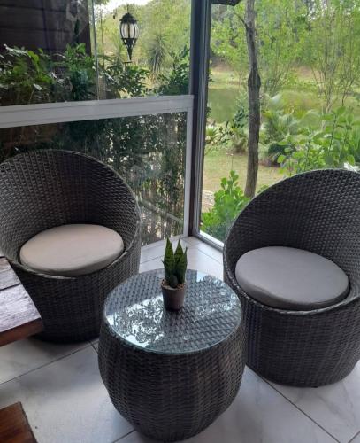 two chairs and a table with a potted plant on a porch at Chalé Veraneio-Itú-SP Vista para o lago Camping Carrion in Itu