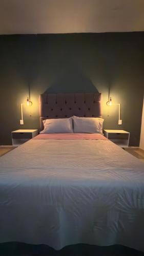 a bedroom with a large bed with two lamps on it at Villa Cerro Escondido in Chiapa de Corzo
