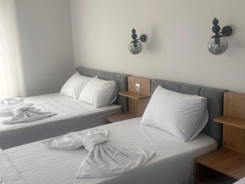 two beds in a room with white sheets and pillows at Avka Palace in Edirne