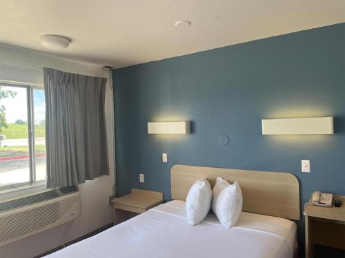 a bedroom with a bed with two pillows on it at Motel 6 Fort Collins, CO in Fort Collins
