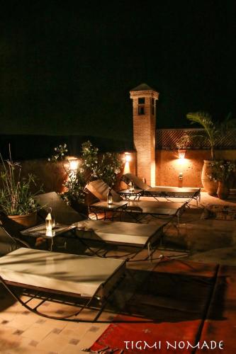a patio with tables and lights at night at Tigmi Nomade in Tahannout