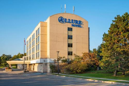 a yellow building with a blue hotel sign on it at Allure Hotel & Conference Centre, Ascend Hotel Collection in Barrie
