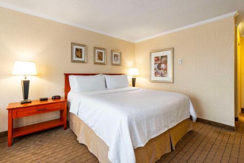 a hotel room with a large bed and a table at Allure Hotel & Conference Centre, Ascend Hotel Collection in Barrie