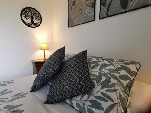 a bedroom with a bed with two pillows on it at Le moulin de La Retardière in Orvault
