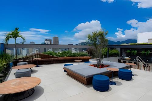 a rooftop patio with tables and benches on a building at Skylux Aptos de Luxo in Rio de Janeiro