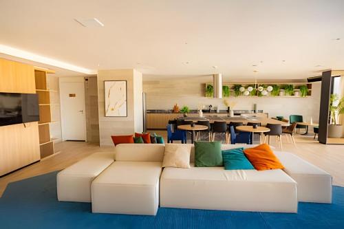 a living room with a white couch with colorful pillows at Skylux Aptos de Luxo in Rio de Janeiro