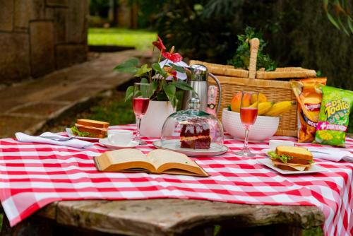 a picnic table with a red and white checkered table cloth at Glamping estilo Hobbit in Curití