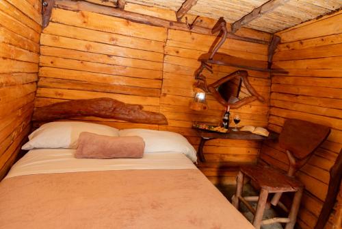 a bedroom with a bed in a log cabin at Glamping estilo Hobbit in Curití