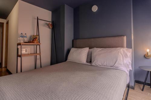 a bedroom with a bed with a blue wall at Soy Local Parque La 93 in Bogotá