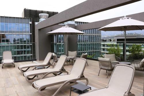 a group of chairs and umbrellas on a balcony at Nuevo y lujoso apartamento full a pasos de Clínica Las Condes in Santiago