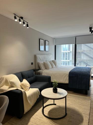 a living room with a bed and a couch at Nuevo y lujoso apartamento full a pasos de Clínica Las Condes in Santiago