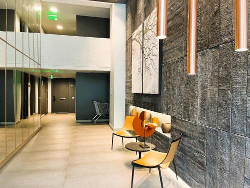 a lobby with chairs and a table in a building at Nuevo y lujoso apartamento full a pasos de Clínica Las Condes in Santiago
