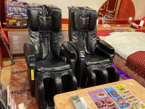 two black leather chairs sitting next to a table at ホテルセリーヌ adult only in Tenri