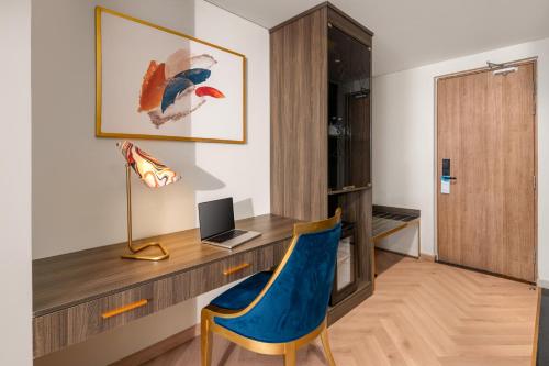a room with a desk with a laptop and a chair at Wyndham Hoi An Royal Beachfront Resort & Villas in Hoi An
