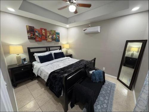 a bedroom with a bed and a mirror and a ceiling fan at 1 BR 1 Bath Airport SpaceX LNG WashDry Yard Patio Pets in Brownsville